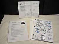 Group view of signed script stack, COA in plastic sleeve, and additional printed documents