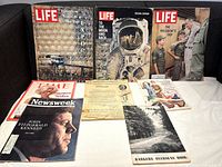 Photo showing 5 vintage magazines and several older catalogues including LIFE, NEWSWEEK and TIME magazines spread on a black surface.