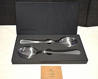 Two-piece serving fork and spoon set displayed in original black box with foam insert and David Mellor studio business card placed below.