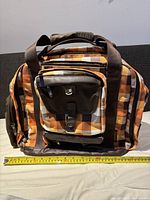 Front view of large Burton vinyl record bag placed on a surface with measuring tape showing about 17 inches width.