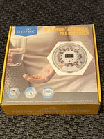 Boxed Livefine Bluetooth Automatic Pill Dispenser with picture on front and blue and yellow branding.