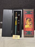 Full view of the miniature sword and sheath set in engraved wooden box along with original film cardboard box cover, showing the overall presentation and packaging.