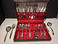 Full set of vintage silver-plated cutlery in original lined box with red velvet insert and satin lid lining.