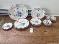 Full view of entire 24-piece Booths china set with English Rose pattern arranged on floor showing various plate sizes and serving platters.