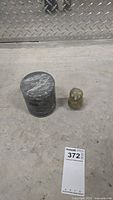 Full view of soapstone covered jar and owl figurine placed on floor with lot number visible