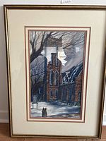 Front view of framed watercolour artwork showing St Judes Anglican Church with two figures in foreground and bare tree branches.