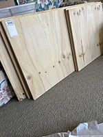 Front view of stacked plywood boards showing natural wood grain and knots.