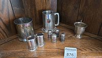 Silver plated lot showing all items: wine coaster, beer mug, cup, and salt & pepper shakers