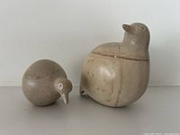 Two soapstone bird carvings side by side showing size and shape, repaired crack visible on larger bird.