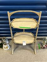 Full view of vintage two-tier folding serving table with visible wear and water stain on top tray.