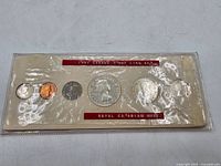 Overall view of sealed 1957 coin set in original plastic sleeve with red Royal Canadian Mint labels and six coins visible