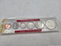 Full view of the set in original plastic packaging showing all seven coins from 1 cent to 1 dollar with red labels for the 1959 Prooflike Set and the Royal Canadian Mint.