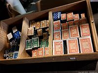 Photo showing multiple compartments of vintage wood screw boxes with assorted sizes and colors.