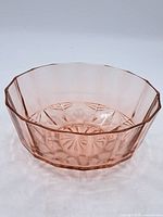 Pink Depression glass bowl showing scalloped octagonal rim and starburst pressed pattern at base.