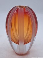 Full view of an oval amber tinted glass vase with vertical frosted stripes, showing shape and color