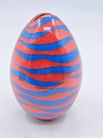 Full view of the red and blue striped egg-shaped ceramic bank showing glossy finish and coin slot on top.