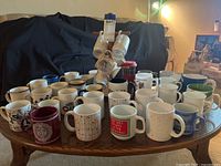 Multiple coffee mugs arranged on wooden table showing variety in color and pattern.