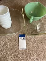 Photo showing the different types of bowls and clear casseroles arranged on carpet surface.