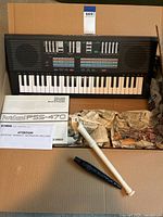Yamaha PortaSound PSS-470 keyboard in box with owner's manual and two recorders (white and black)