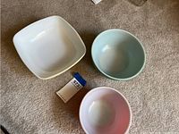 Three Pyrex bowls: white square, light blue round, and pink round