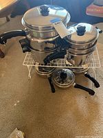 Stacked double boiler set and smaller pot assembly on white rack