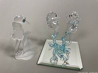 Both seahorse figurines and mirrored display base shown together