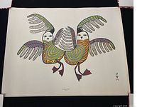 Full view of the Inuit stone cut print showing two stylized birds in yellow, red, blue, black, and white on a cream background with artist signature and title at the bottom.