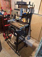 Full view of bandsaw on rolling metal stand in basement workshop