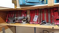 Wide view showing milling vise mounted on angle base, small anvil to the left, hand plane, and two red fabric rolls with filing sets behind them.