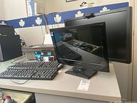 Two monitors and two keyboards placed on a desk, including Dynex and Acer monitors.