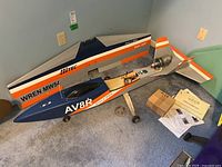 Overview of fuselage and one wing panel on carpeted floor