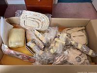 Overall contents in cardboard box showing balsa formers, plastic cowl, fuel tanks, strut, drawings
