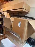 Stack of five cardboard boxes on shelving