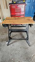 Overall front view of Workmate 400 workbench showing wooden top and black metal frame in garage environment.