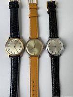 Front view of three vintage Timex men's watches with different strap colors on white background