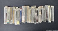 Full view of approximately 35 vintage watch bracelets in original plastic cases, laid out side-by-side showing variety and quantity in the lot.