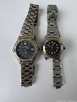 Two Swiss Military women's watches side by side on white background, showing full watches and metal bands.