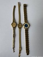 Three vintage women's watches laid flat showing full bands and faces.