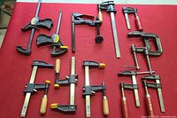 All clamps laid out on red background showing shape, brand, and handles.