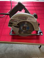 Full side view of circular saw showing blade size, handle, and power cord.