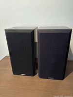 Front view of the pair of Energy speakers. Both have black fabric speaker grills with Energy logos centered near bottom.