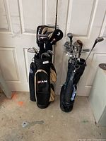 Two sets of right-handed golf clubs in two bags standing side-by-side. Each bag contains various clubs including hybrids, irons, wedges, and woods.