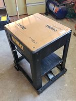 Front and top side view of Dewalt planer bench cart showing sturdiness and work surface with logos.