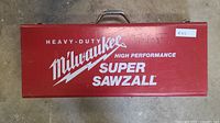 Closed red metal Milwaukee carry case with branding on top.