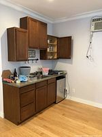 Fully assembled kitchen bar setup installed with dark wood cabinetry, countertop, dual sink and faucet visible, mini fridge not included