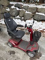 Front-left view of red scooter with black seat and front basket.