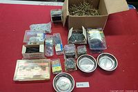 Overall lot showing assorted screws, boxes, and three metal magnetic screw dishes.
