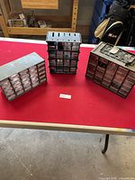 Three storage units with multiple drawers placed on a table, showing exterior view