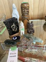 Wide view of all carved figures and items on glass surface, showing scale and relation