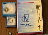 Overview of four 14k gold items: maple leaf pin, two rings, chain